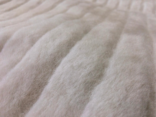 A close-up shot of the fabric of a pet bed, showing its texture and breathability. The focus is on the small pores in the fabric that allow for air circulation.