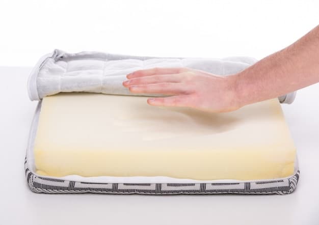 A close-up shot of a hand pressing into the memory foam of an orthopedic dog bed, showing its density and responsiveness.