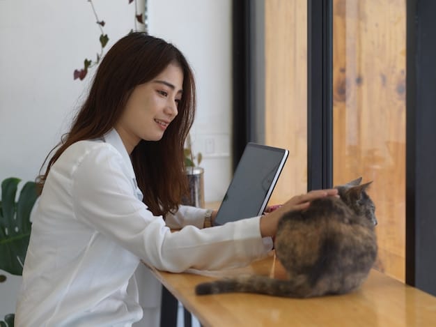 A veterinarian consulting with a cat owner, showing them a vaccination schedule chart on a tablet. The cat is sitting calmly on the owner's lap.