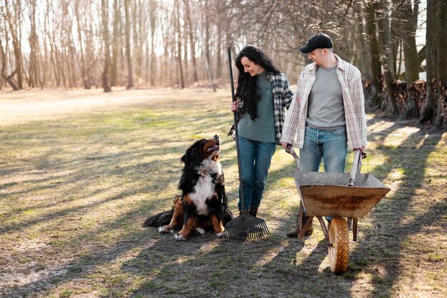 Two dogs, a beagle and a terrier, are sniffing noses in a friendly manner at the entrance of a dog park. Their owners are standing nearby with leashes in hand, observing the initial interaction.